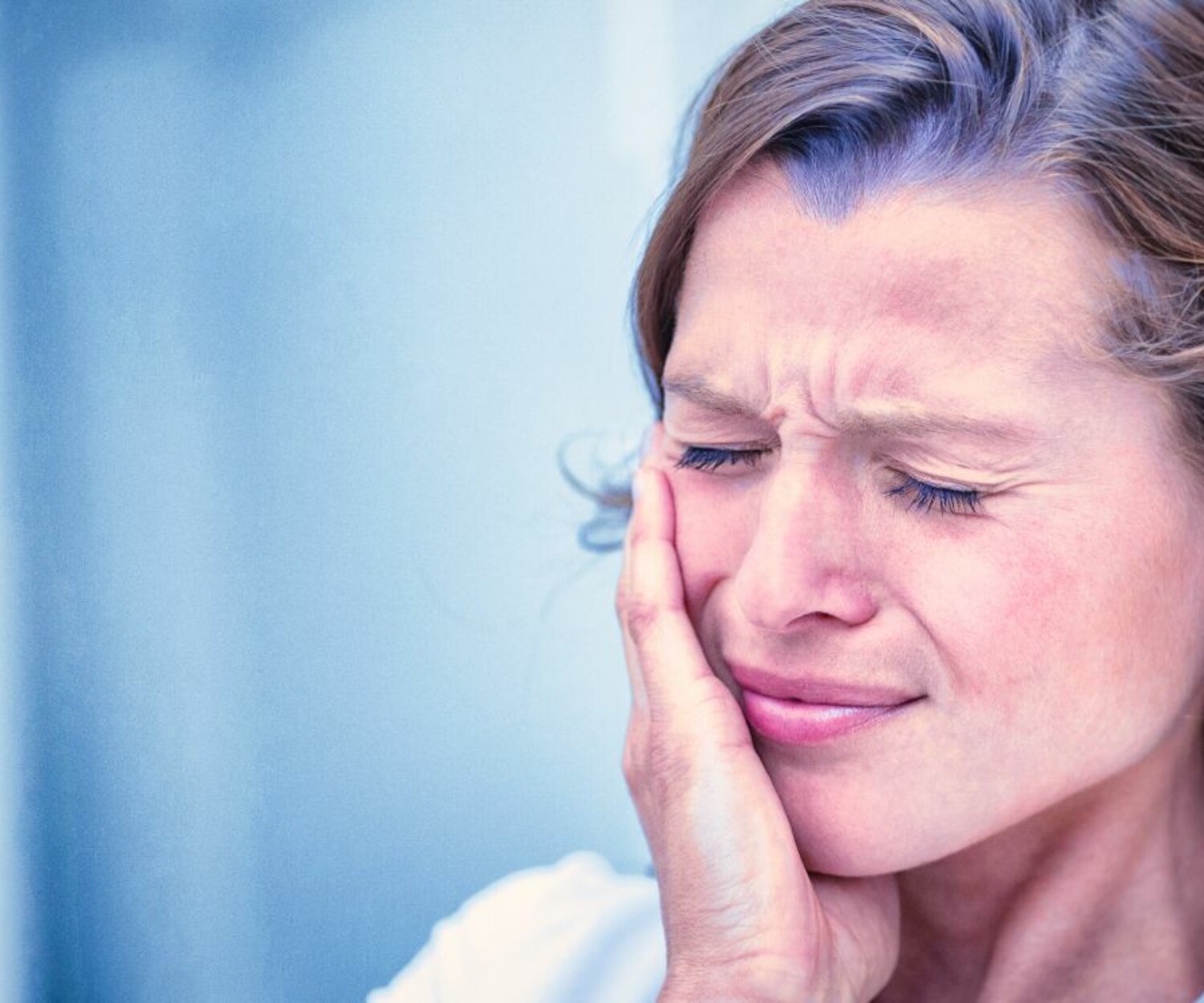 Mujer con dolor de mandíbula.